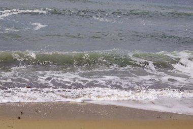 Yazın kumlu sahildeki okyanus dalgalarının güzel manzarası.