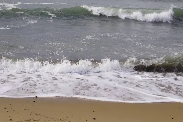 Akdeniz 'in dalgaları kumlu sahilde kırılıyor.