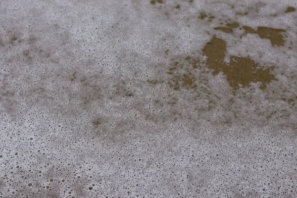 Denizin yüzeyinde köpük, okyanusun soyut arka planında.