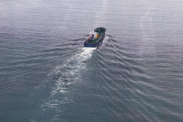 Mavi denizde giden bir kargo gemisinin hava görüntüsü. Yukarıdan görüntüle.