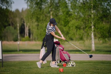 Golf sahası golf sahası sahası. İnsanların yaşam tarzı kadın golf oynuyor ve yeşil çimlere vuruyor. Yazın bayan oyuncu oyunu vuruşu. Sağlıklı ve açık hava sporu