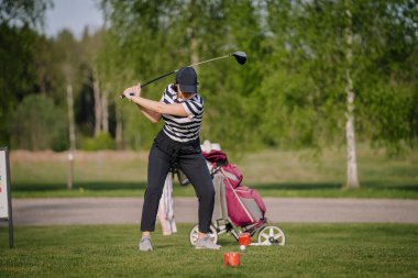 Golf sahası golf sahası sahası. İnsanların yaşam tarzı kadın golf oynuyor ve yeşil çimlere vuruyor. Yazın bayan oyuncu oyunu vuruşu. Sağlıklı ve açık hava sporu