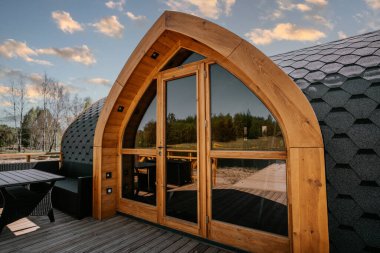 Igloo saunası, gölün kıyısında tahta kaldırımlı.
