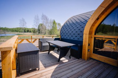 Igloo saunası, gölün kıyısında tahta kaldırımlı.