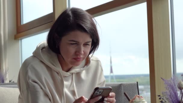 Młoda Kobieta Siedzi Restauracji Widok Okna Miasto Góry Trzyma Telefon — Wideo stockowe