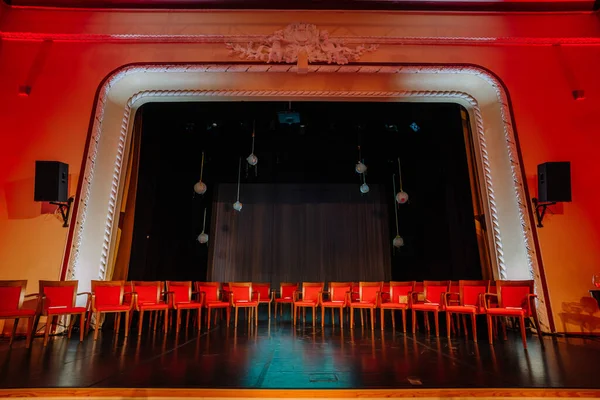 Red chairs are arranged on the Theater stage