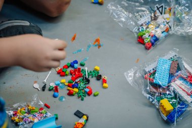 Masada renkli plastik tuğlalarla oynayan çocukların ellerini kapatın.