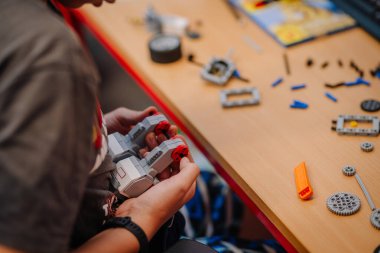 Küçük çocuk ellerini yeni bir şekle sokarken, bloklardan plastik oyuncak arabaya odaklan..