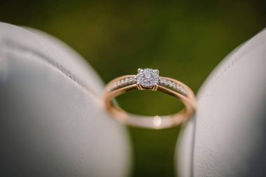 Gelinin düğün ayakkabıları arasındaki nişan yüzüğü inanılmaz. Koyu ahşap arka planda kadın ayakkabıları. Düğün detayları konsepti