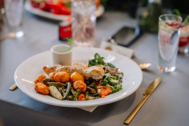 Zarif bir restoranda veya otelde lezzetli ızgara somon, mısır, patates ve salata servis edilir..