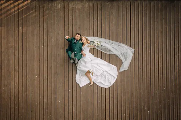 신부와 신부는 호수의 해안에 제티에 누워있다 결혼식 행복한 사랑에 남자와 — 스톡 사진