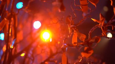 Parlayan ışıkları olan bulanık renkli bir çelenk. Yumuşak odaklan, bokeh, makro. Siyah arka planda kırmızı ışıklar yanıp sönüyor. Parlayan ışıkları olan bulanık renkli bir çelenk. Soyut odaklanmış bokeh arkaplanı