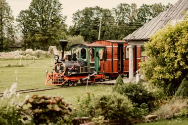 Eski küçük buhar treni gururla müzede sergileniyor. Lokomotif cazibesinin eskimiş bir döneminin durağan ama anımsatıcı sembolü.