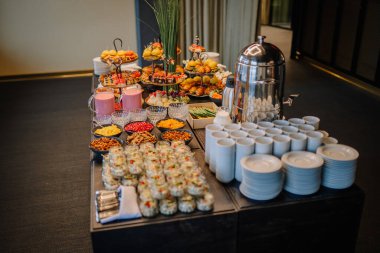 Güzel dekore edilmiş tabakları olan siyah büfe masası. Otelde kahvaltı. Yemek servisi. Ziyafet için dekorasyon