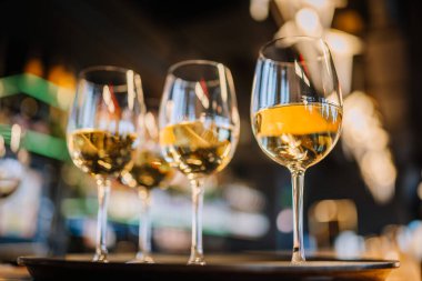 Şampanyalı ve şampanyalı bardaklar altın gibi parlak arka planda parlıyor.