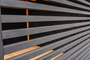 Yatay ahşap ev duvarındaki bej rengi ahşap çit dokusu davetkar alanlarla büyüleyici bir desen oluşturuyor..