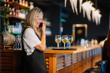 Riga, Letonya - 6 Kasım 2023 Moda kıyafetleri içinde güzel bir kadın erkek arkadaşıyla akıllı telefonda konuşuyor..