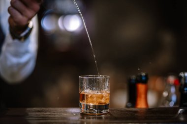 Barmen viski ikram ediyor, ahşap barda..