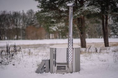 Kışın açık havada sıcak bir banyo. Banyo için demir küvet.