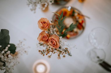 Restoranda güller, yeşillikler ve orkide çiçekleri olan güzel düğün süsleri.