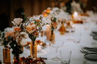 Restoranda güller, yeşillikler ve orkide çiçekleri olan güzel düğün süsleri.