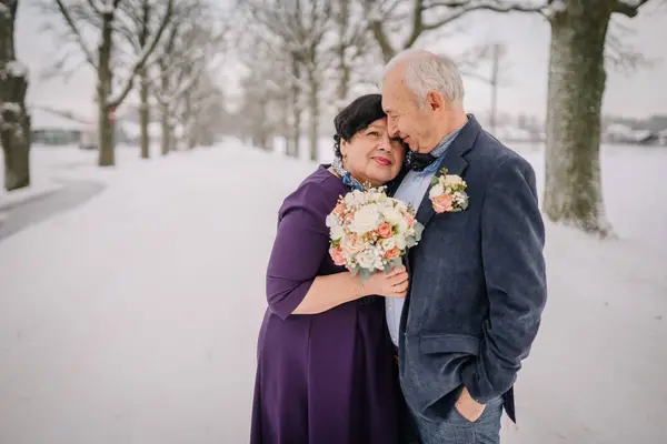 A winter wedding features a radiant senior bride and groom, a mature couple celebrating their love amidst the enchanting backdrop of the season.