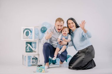 Anne, baba ve oğul ilk yıl dönümünde balonlarla stüdyoda.