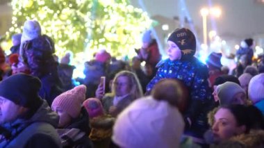 Valmiera, Riga - 3 Aralık 2023 - Noel ağacı ışıklandırması. Çocuklar, gösteriler, Noel ağacı. Kışın şehir merkezinde karanlıkta bir sürü mutlu insan var.