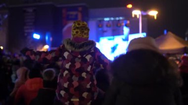 Valmiera, Riga - 3 Aralık 2023 - Noel ağacı ışıklandırması. Çocuklar, gösteriler, Noel ağacı. Kışın şehir merkezinde karanlıkta bir sürü mutlu insan var.