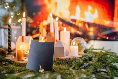 Noel için dekore edilmiş odada, masada mum yakmak.