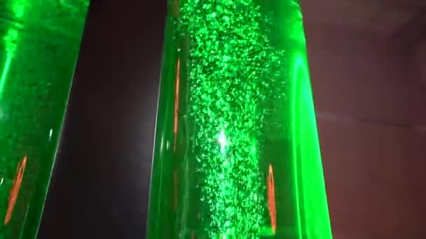 由Led灯照亮的双绿色泡状液体填充管 设置在宽敞的室内环境中的黑暗背景下 可能是一个科学展览 — 图库视频影像