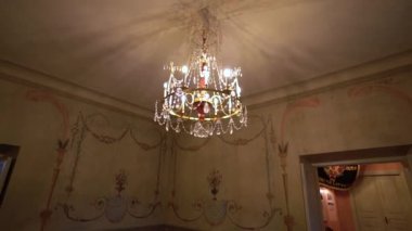 Tavana asılan lüks Viktorya tarzı avize altın sarısı, ampuller aydınlatma odası, klasik avizeyi süsleyen kristal kolyeler. Sarayda sallanan lamba.,