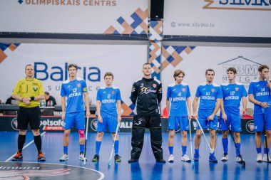 Valmiera, Letonya - 15 Aralık 2023 - iki erkek zemin topu takımı kapalı alanda birbirlerine karşı oynuyorlar. Oyun anları ve taraftarlar. Uygunsuz spor.