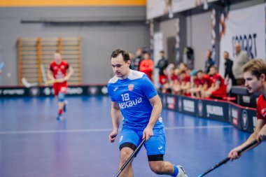 Valmiera, Letonya - 15 Aralık 2023 - iki erkek zemin topu takımı kapalı alanda birbirlerine karşı oynuyorlar. Oyun anları ve taraftarlar. Uygunsuz spor.