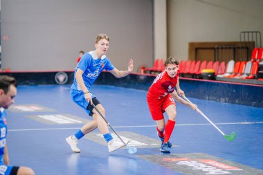 Valmiera, Letonya - 15 Aralık 2023 - iki erkek zemin topu takımı kapalı alanda birbirlerine karşı oynuyorlar. Oyun anları ve taraftarlar. Uygunsuz spor.