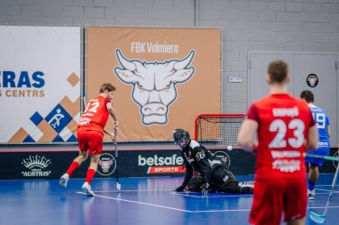 Valmiera, Letonya - 15 Aralık 2023 - iki erkek zemin topu takımı kapalı alanda birbirlerine karşı oynuyorlar. Oyun anları ve taraftarlar. Uygunsuz spor.