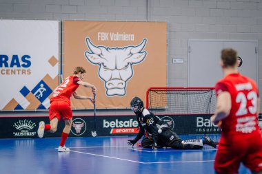 Valmiera, Letonya - 15 Aralık 2023 - iki erkek zemin topu takımı kapalı alanda birbirlerine karşı oynuyorlar. Oyun anları ve taraftarlar. Uygunsuz spor.