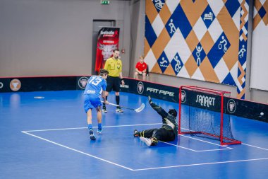 Valmiera, Letonya - 15 Aralık 2023 - iki erkek zemin topu takımı kapalı alanda birbirlerine karşı oynuyorlar. Oyun anları ve taraftarlar. Uygunsuz spor.