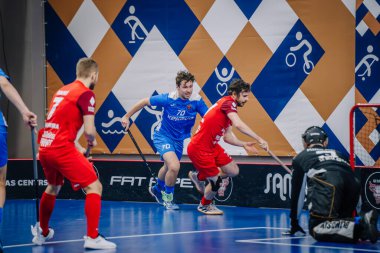 Valmiera, Letonya - 15 Aralık 2023 - iki erkek zemin topu takımı kapalı alanda birbirlerine karşı oynuyorlar. Oyun anları ve taraftarlar. Uygunsuz spor.