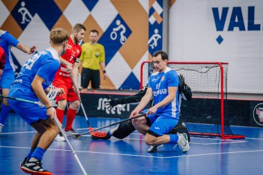 Valmiera, Letonya - 15 Aralık 2023 - iki erkek zemin topu takımı kapalı alanda birbirlerine karşı oynuyorlar. Oyun anları ve taraftarlar. Uygunsuz spor.