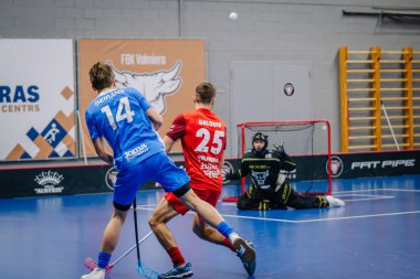 Valmiera, Letonya - 15 Aralık 2023 - iki erkek zemin topu takımı kapalı alanda birbirlerine karşı oynuyorlar. Oyun anları ve taraftarlar. Uygunsuz spor.