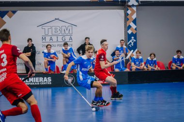 Valmiera, Letonya - 15 Aralık 2023 - iki erkek zemin topu takımı kapalı alanda birbirlerine karşı oynuyorlar. Oyun anları ve taraftarlar. Uygunsuz spor.