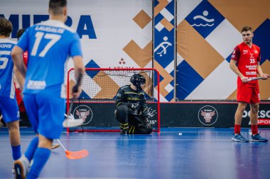 Valmiera, Letonya - 15 Aralık 2023 - iki erkek zemin topu takımı kapalı alanda birbirlerine karşı oynuyorlar. Oyun anları ve taraftarlar. Uygunsuz spor.