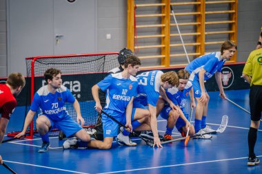 Valmiera, Letonya - 15 Aralık 2023 - iki erkek zemin topu takımı kapalı alanda birbirlerine karşı oynuyorlar. Oyun anları ve taraftarlar. Uygunsuz spor.