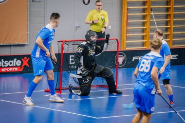 Valmiera, Letonya - 15 Aralık 2023 - iki erkek zemin topu takımı kapalı alanda birbirlerine karşı oynuyorlar. Oyun anları ve taraftarlar. Uygunsuz spor.