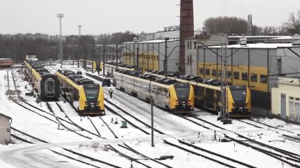 Σιδηροδρομικό Σταθμό Πολλαπλές Κίτρινες Επιβατικές Αμαξοστοιχίες Σταθμευμένες Χιονισμένες Τροχιές Υπάρχουν — Αρχείο Βίντεο