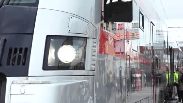 近景侧景的现代化客运列车 重点是列车的前灯和部分驾驶舱区域 火车的反射面显示出周围地区模糊不清的反光 — 图库视频影像