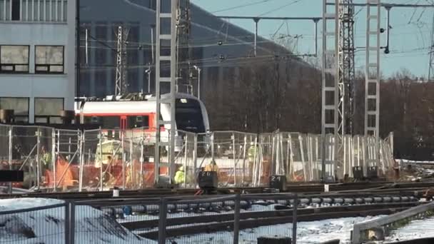 ラトビア 2023年12月27日 近代的な旅客列車が到着または駅を出発し 冬季の条件を示す雪の鉄道トラック — ストック動画