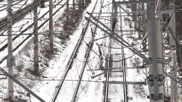 铁路轨道 高架线路和信号站的复杂网络 轨道和交换器相互交织在一起 地面上满是雪 架空线路设备的钢结构在寒冷的背景下脱颖而出 — 图库视频影像