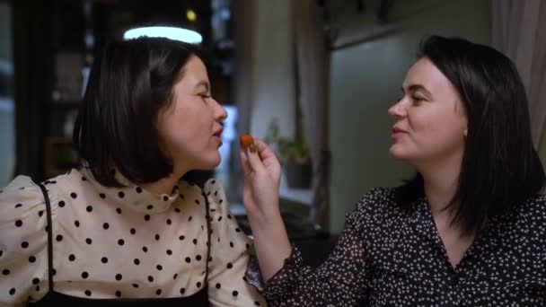 Δύο Γυναίκες Κάθονται Ένα Τραπέζι Μια Γυναίκα Δίνει Μια Φράουλα — Αρχείο Βίντεο